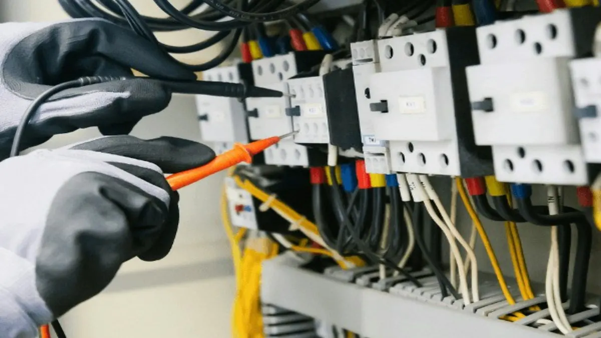 Electrician testing a commercial electrical panel with a multimeter